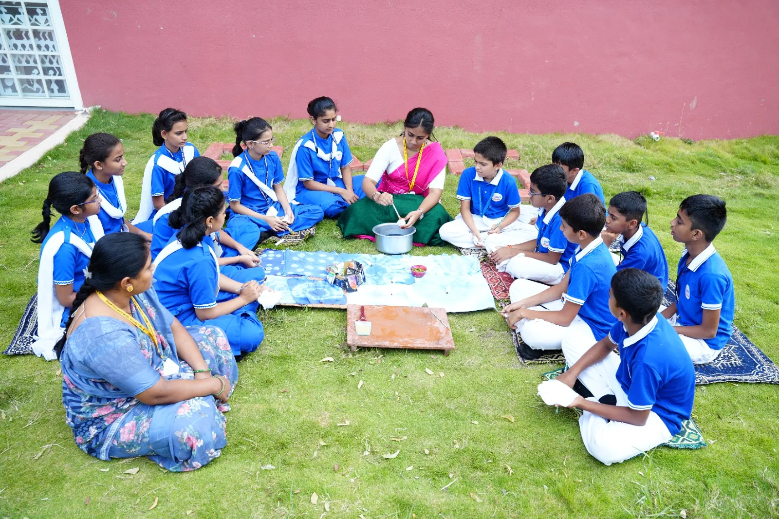 Students working on a craft and dyeing project on the school lawn