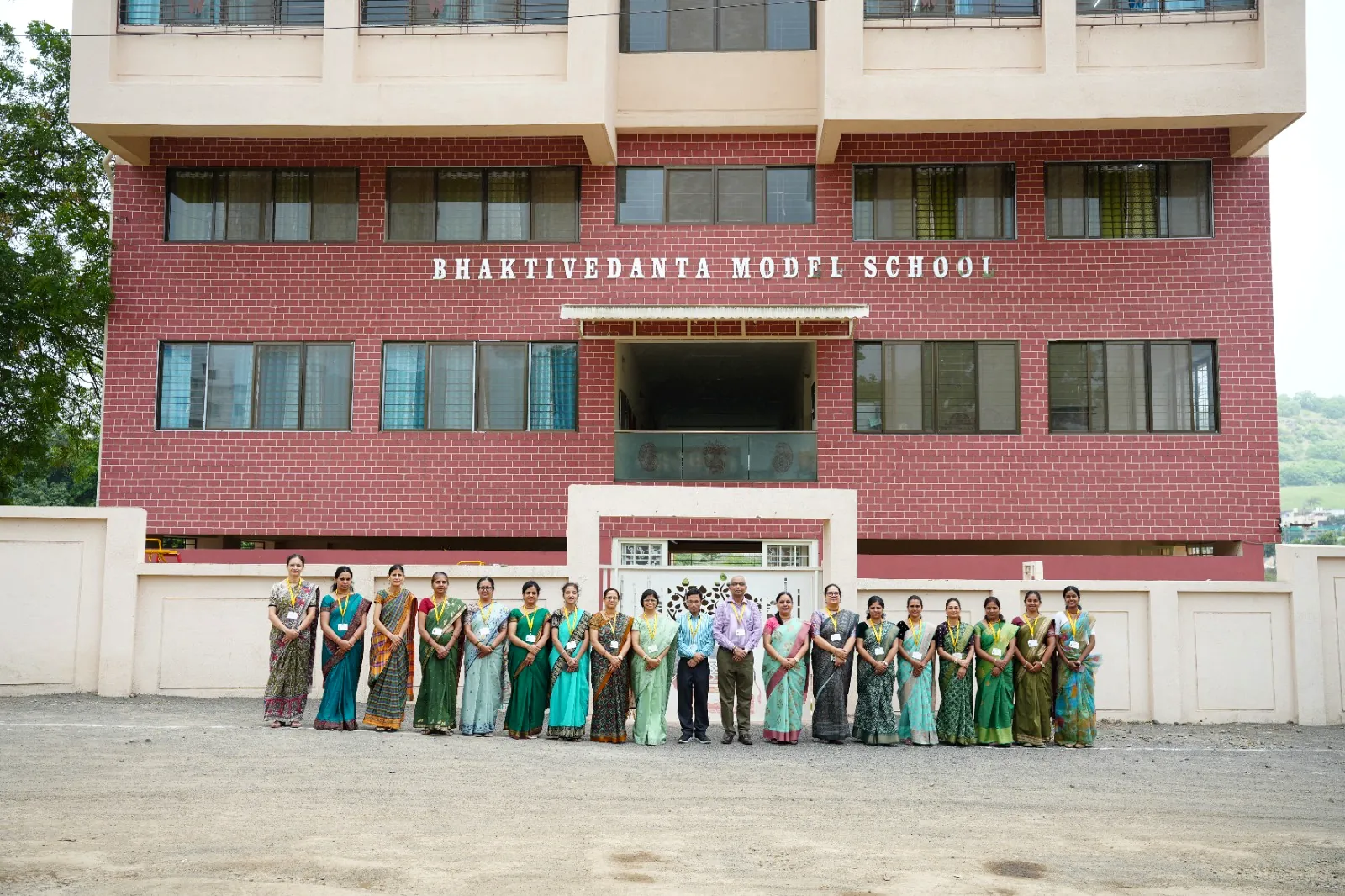 The main entrance of the school with staff gathered on the forecourt