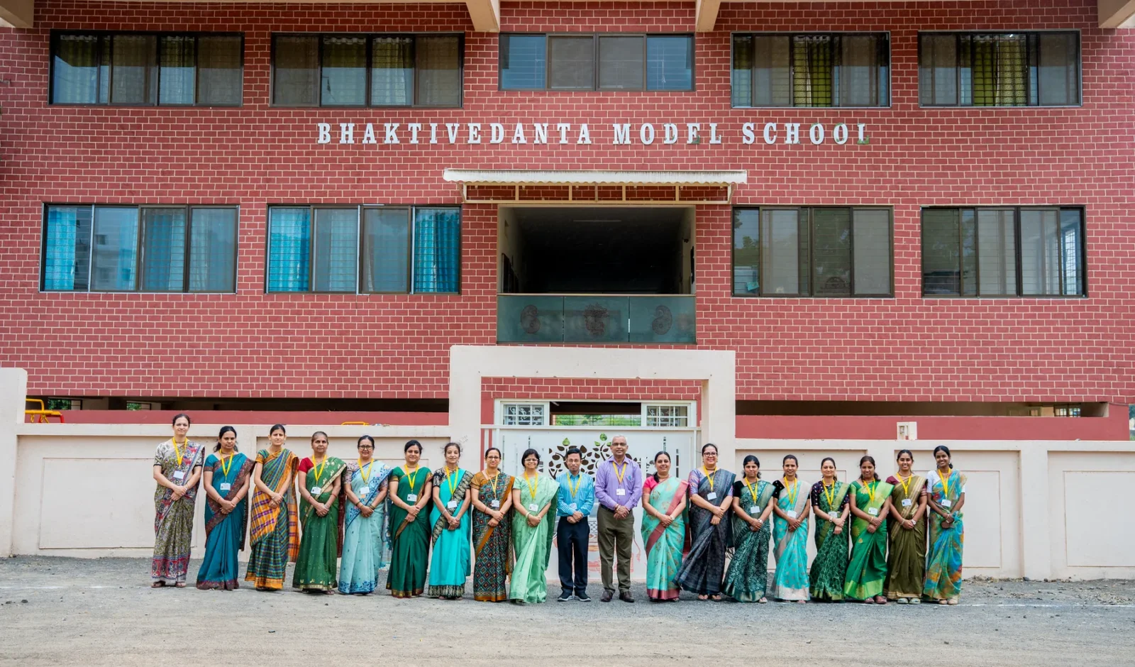 The Bhaktivedanta Model School building with staff and students assembled in front of it