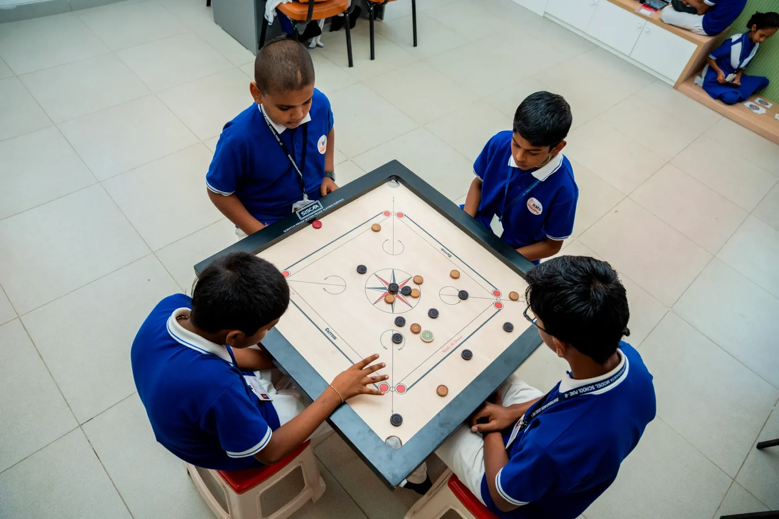 Students playing carrom during the games period