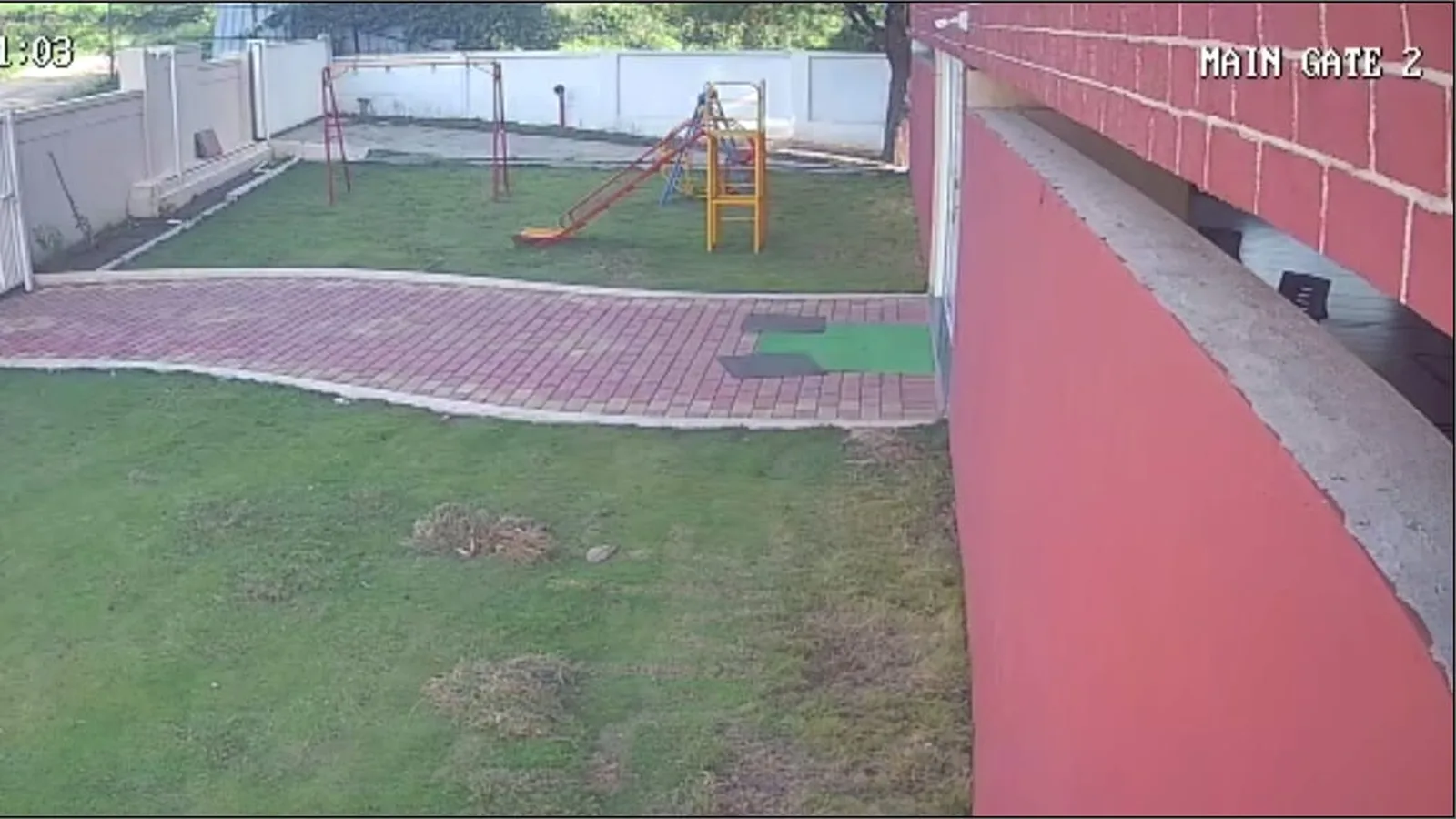 A camera view of the play area and the main gate as it appears on the school's CCTV monitor