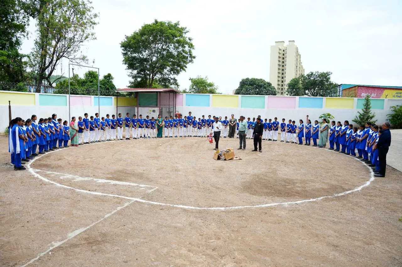 The full school ground with students assembled around its edge