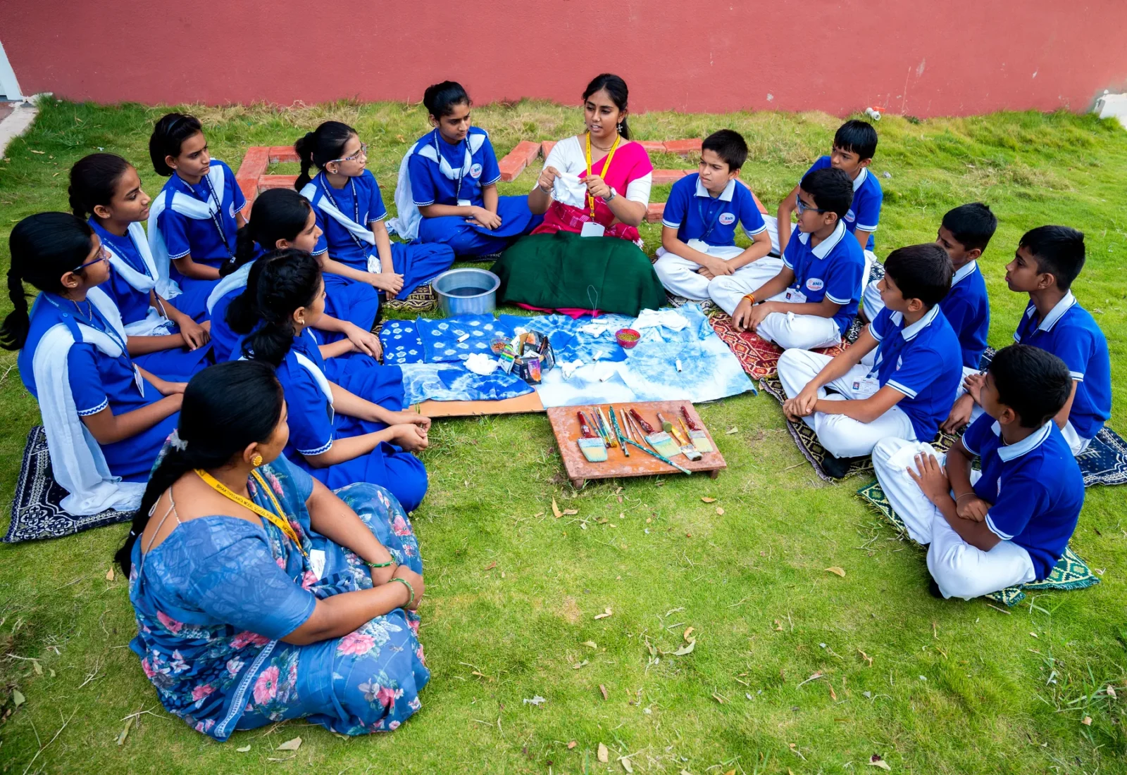Classes seated on the lawn in groups for an outdoor lesson