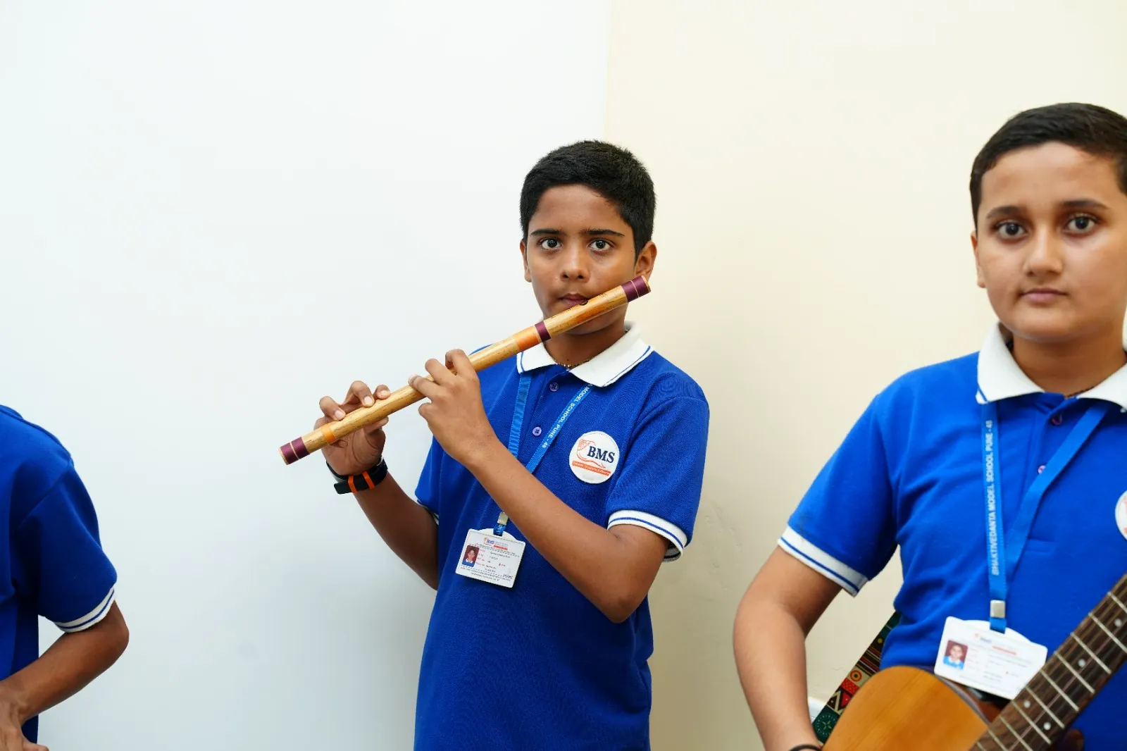 Two students playing the flute and a stringed instrument in the music room