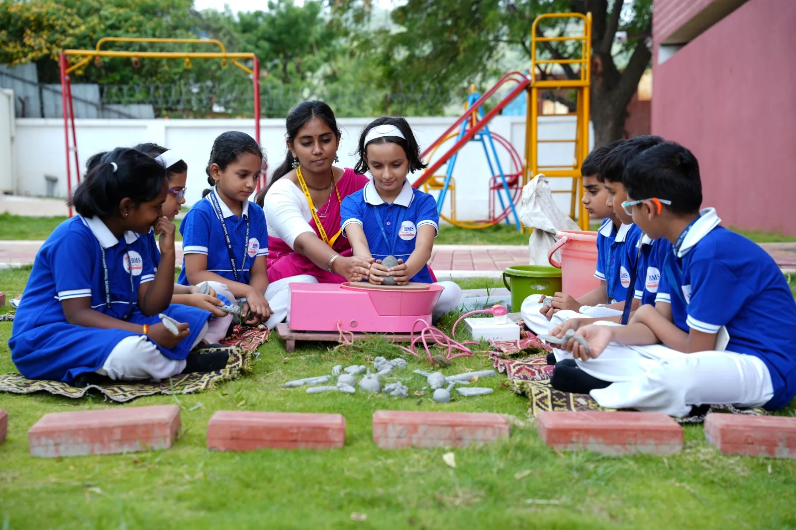 Primary students at a pottery and clay activity beside the play area