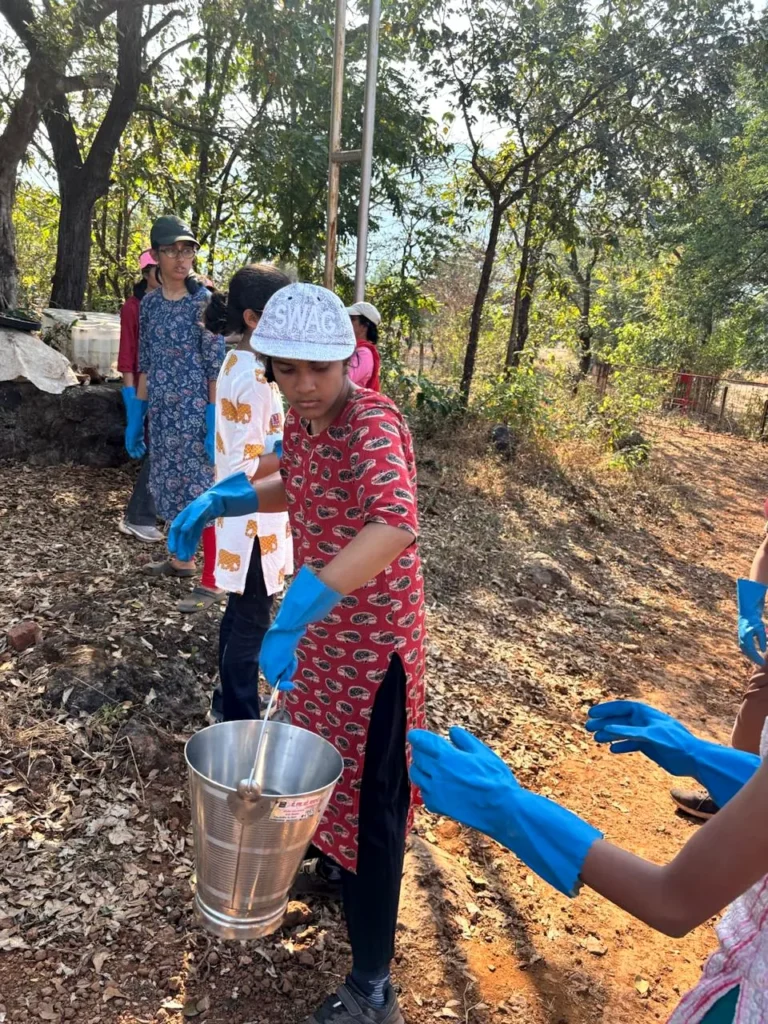 A student carrying a bucket of water during a community service build