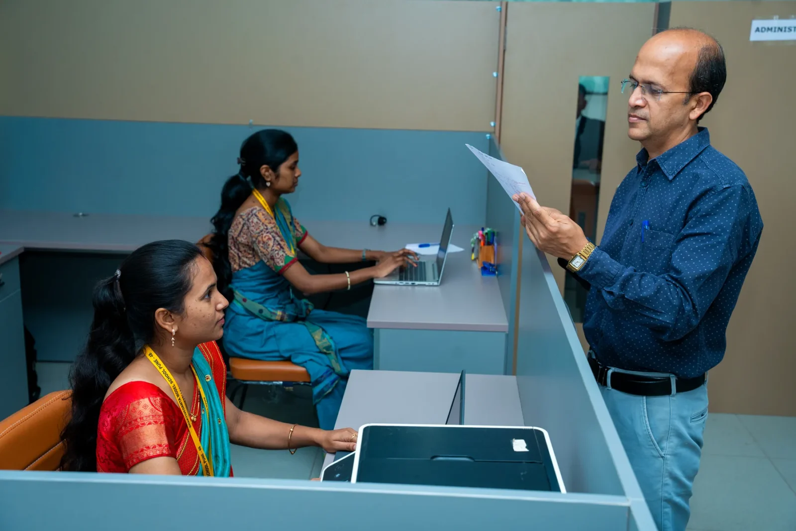 A member of staff being handed a form at the reception desk