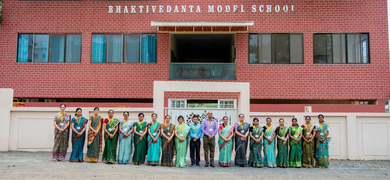 The school building with staff assembled in front of it